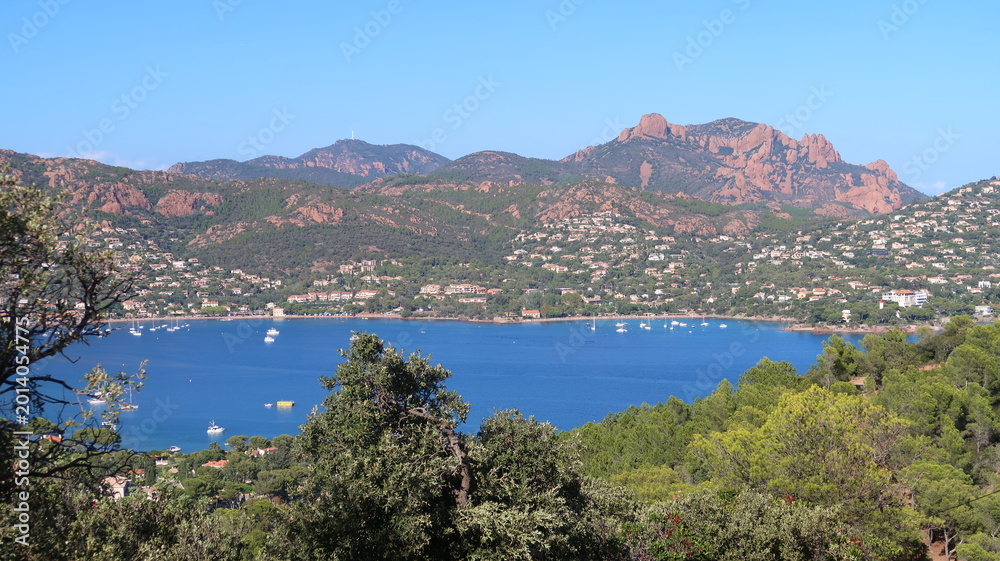 Fototapeta premium Panorama sur la rade d’Agay (Saint-Raphaël / Var), la mer Méditerranée et le massif de l’Estérel : vue, depuis le Dramont, sur une partie du Rastel, le pic du Cap Roux et le pic de l’Ours (France)