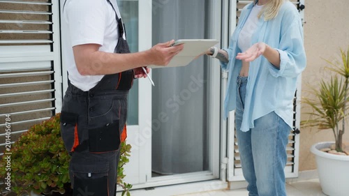 Woman refuses to sign for a package at doorstep while delivery courier waits with device. Delivery issue, service dispute, and customer decision concept in logistics.