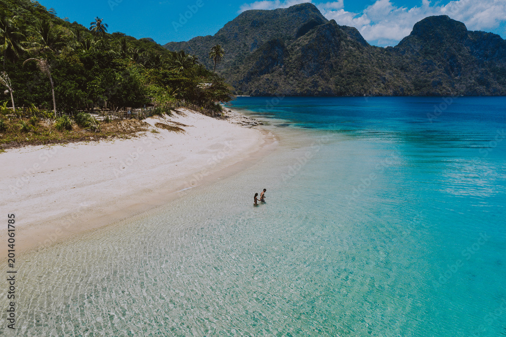 Fototapeta premium Couple enjoying time in front of the beach in Coron. Concept about summer, lifestyle,wanderlust travel and nature
