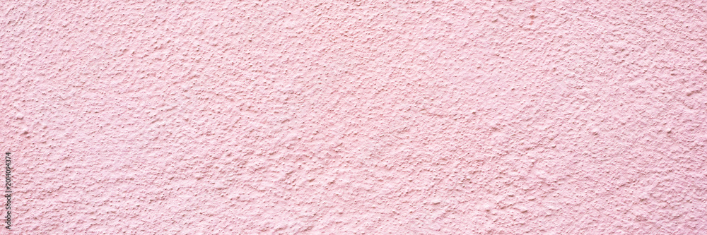 Fototapeta premium Pink textured wall surface with rough appearance showing colors and patterns in natural light during the day