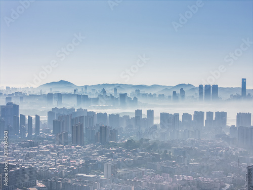 Aerial View of Urban Skyscrapers Emerging from Morning Mist in a Modern Cityscape