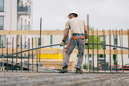 Bauarbeiter trägt Eisenstangen auf Baustelle