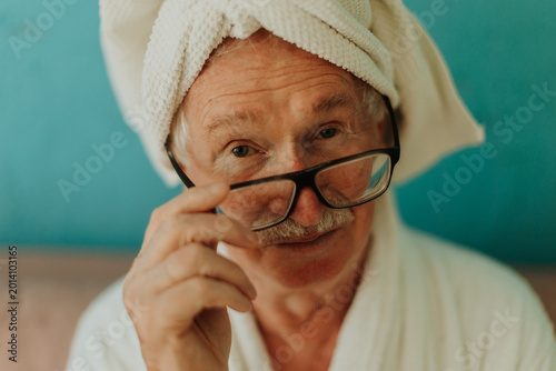 Bilde på lerret Senior man with hair wrapped in a towel after shower.