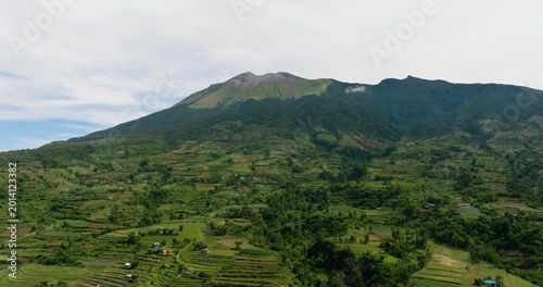 Farmland against a background of mountains and blue sky view from above. Canlaon volcano. Negros, Philippines