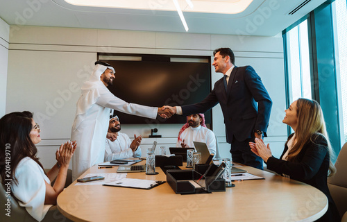 Foto Businessmen shaking hands celebrating successful diverse partnership