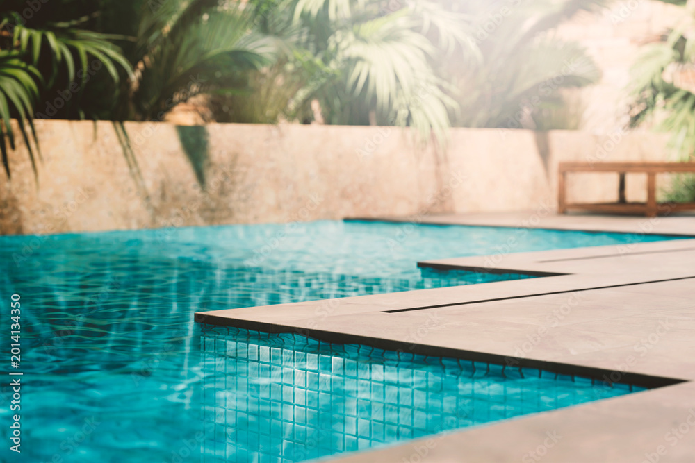 Fototapeta premium Luxury pool closeup edge with granite tiles and tropical garden. Summer travel hotel resort. Poolside product placement for beauty brand display. Modern aesthetic architecture design.