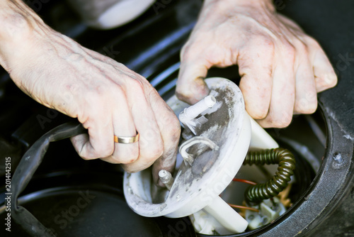 Foto Close-up of hands of a technician repairing a car fuel pump assembly, showing in