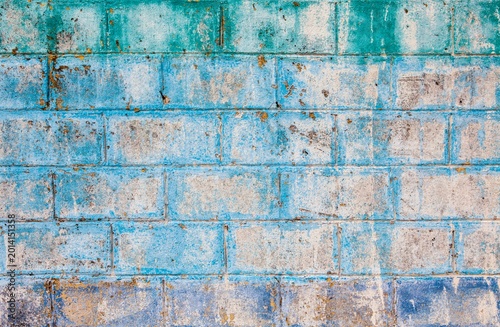 Aged and textured cinder block wall with fading blue, green, and purple paint, Mexico
