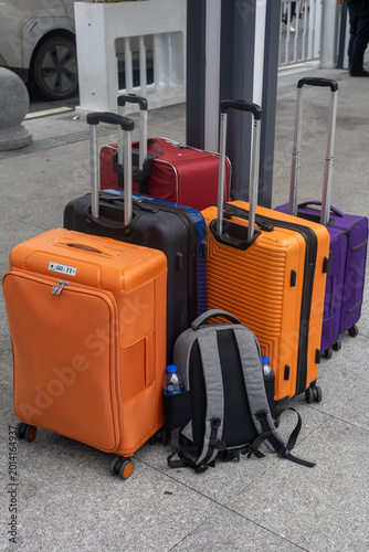 Colorful travel suitcases and backpack standing together at transport terminal in Guangzhou China ready for vacation journey
