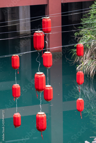 Traditional red Chinese lanterns hanging above calm water in decorative cultural scene in Guangzhou China