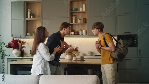 Adolescent boy arguing with displeased parents at home, family conflict