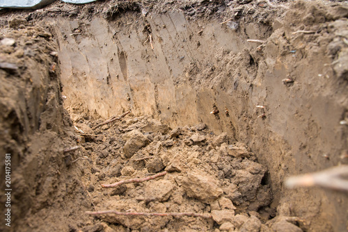 Foto Dirty soil in the garden after digging a hole in the ground