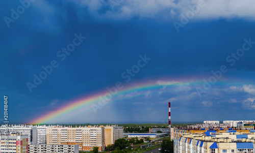 Fantastic beautiful rainbow over city buildings after rain