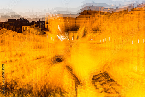 Zoom burst. Blurry photo of city with yellow tone, Sovana, Tuscany, Italy, long exposure motion blur