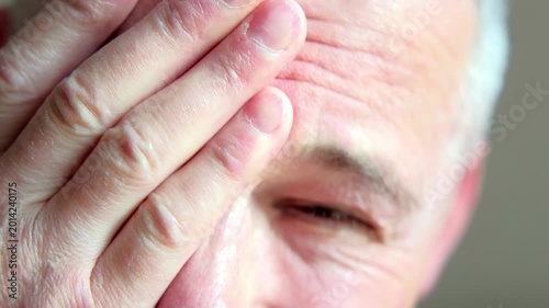 Anxious investor stressed. Seasoned broker displays signs of fatigue and anxiety following monetary losses in subdued workspace