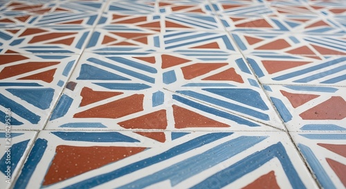 Traditional geometric mosaic floor tiles in white blue and terracotta colors.