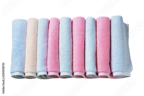 Fotografie Isolated neat row of soft colorful rolled terry cloth towels in light pastel sha