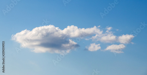 Solitary white cloud floating in the blue sky on a sunny day, creating a sense of calm and tranquility