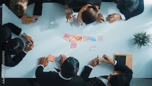 Tableau sur toile Top down aerial view of businesswoman give sticky notes to participant before start meeting