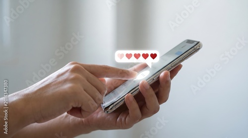 Person's hands using smartphone and giving a heart rating with social media opinion poll feedback form feedback smartphone experience positive evaluation