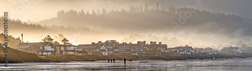 Morning fog in the valleys of the coast mountain range with ocean front homes in forground, Seaside, Oregon