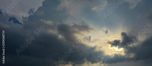 Tableau sur toile Dramatic Stormy Sky with Sun Breaking Through Dark Clouds.