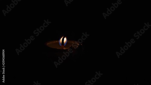 Lighted candle flame in darkness creating a calming atmosphere  