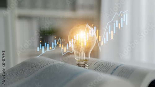 Obraz na płótnie A light bulb sits atop an open book, symbolizing bright ideas and innovation