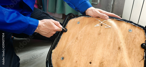 Foto Repairing a chair by tightening screws and adjusting parts in a workshop