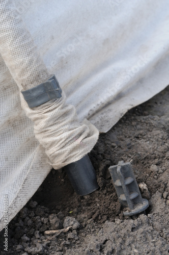 Close-up of fixing the greenhouse to the ground.