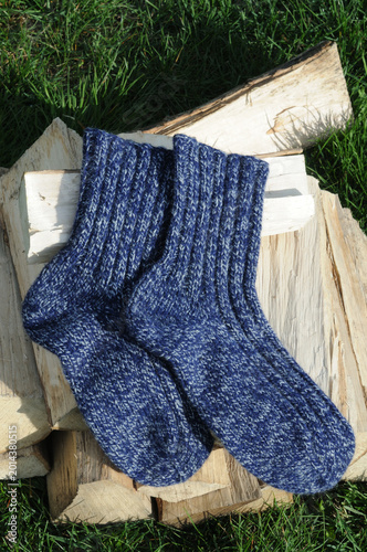 A pair of wool socks on a pile of firewood in the garden.