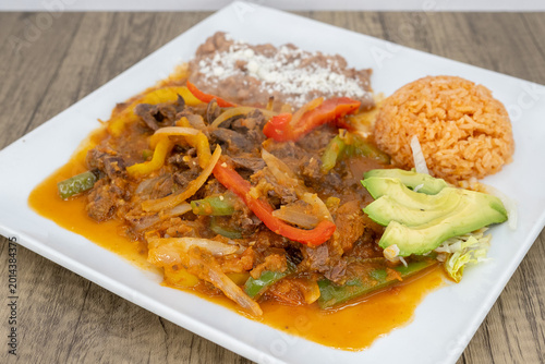 Bilde på lerret Hearty plate of bistec steak smothered in ranchero sauce, beans, and rice to sat