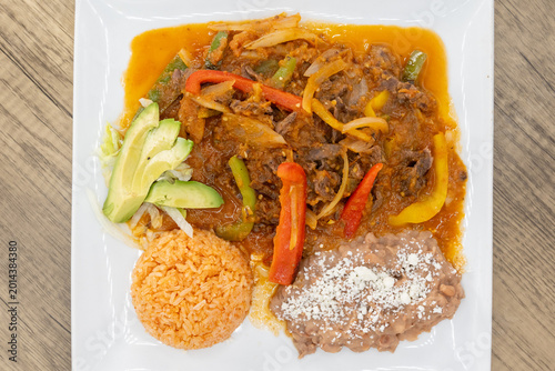 Canvas Print Overhead view of hearty plate of bistec steak smothered in ranchero sauce, beans