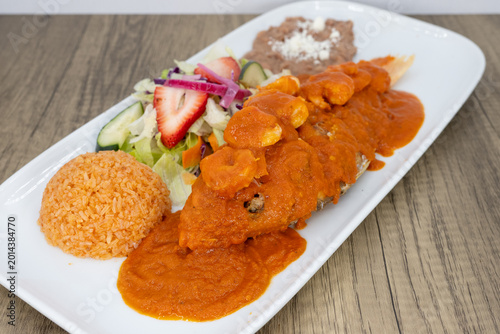 Foto Hearty plate of whole red snapper fish topped with shrimp, smothered in red sauc