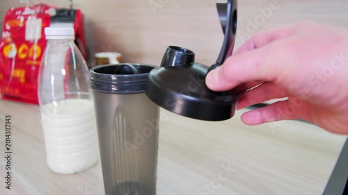 Morning protein preparation. Preparing milkshake by hand. Milk and shaker sit on kitchen counter during morning routine