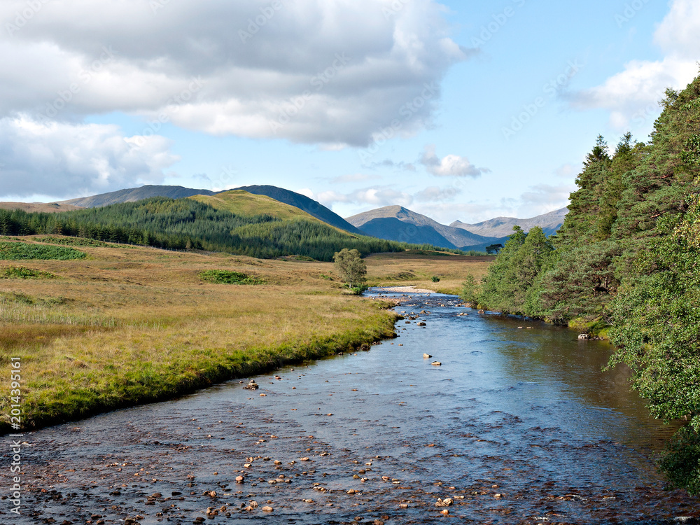 Fototapeta premium The view west from the West Highland Way on Rannoch Moor at Victoria Bridge of the Abhainn Shira river, Beinn Suidhe, Beinn nan Aighenan and Ben Starav. Argyll, Scottish Highlands.