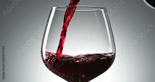 Elegant red wine pouring into crystal glass with smooth liquid flow and dynamic motion for luxury dining concept