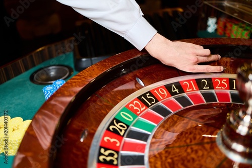 Casino Roulette Wheel Close Up with Dealer Hand