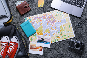 Planning trip. Laptop, camera, map and travel accessories on floor, flat lay