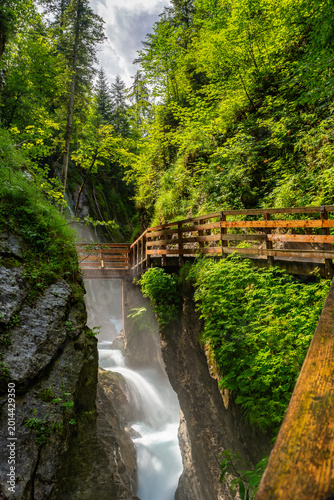 Wimbachklamm in Ramsau shows a gorge with a river and wooden walkways in the greenery of Bayern, attracting travelers.
