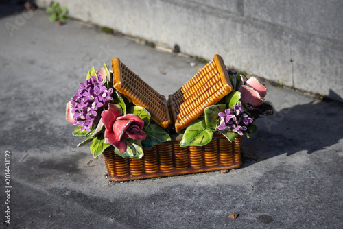 Ceramic flower basket memorial decoration on cemetery grave