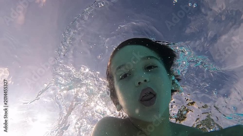 Young boy panicing in pool as he swims - underwater view
