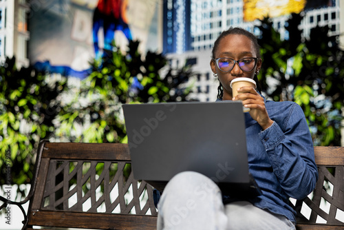 Photos Drinking coffee, laptop and digital nomad working on city park bench