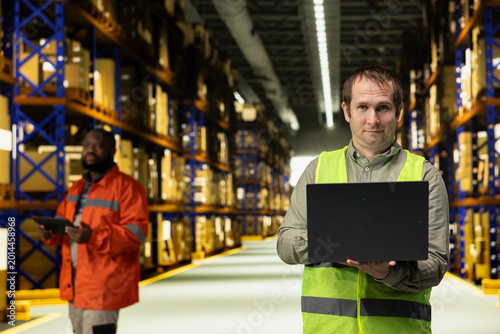 Fotografie Portrait of worker securing packages for dispatch in industrial facility