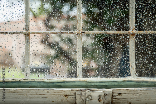 Tableau sur toile ventana clasica de madera de pinotea con el vidrio lleno de gotas de lluvia y la