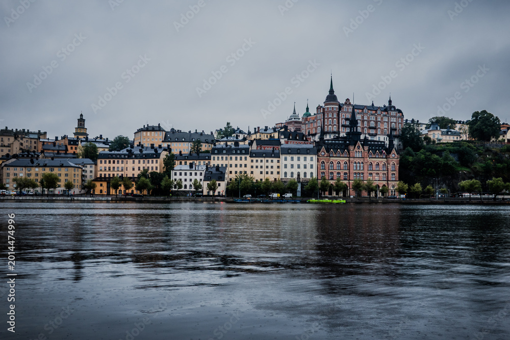 Fototapeta premium Stockholm Sweden Södermalm Waterfront with Historic Münchenbryggeriet Building and Boat on Calm Water Under Overcast Sky