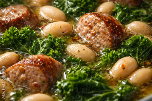 A close macro detail reveals sausage white bean kale soup textures highlighting fiber rich ingredients and glossy broth surface