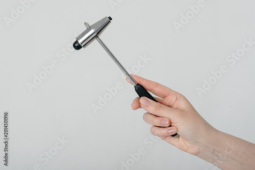 Принти на полотні neurologist holds neurological reflex hammer for testing human reflexes in hand,
