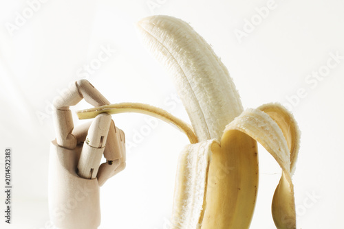 banana on a white background, The hand that opens a banana, wooden sketching hand