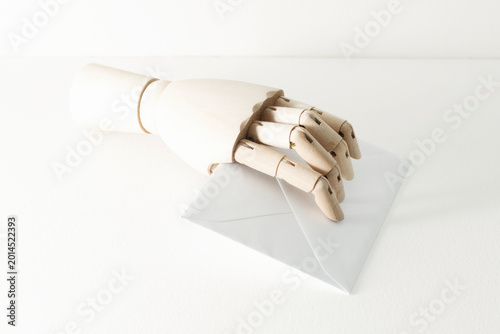 wooden sketching hand holding paper letter
